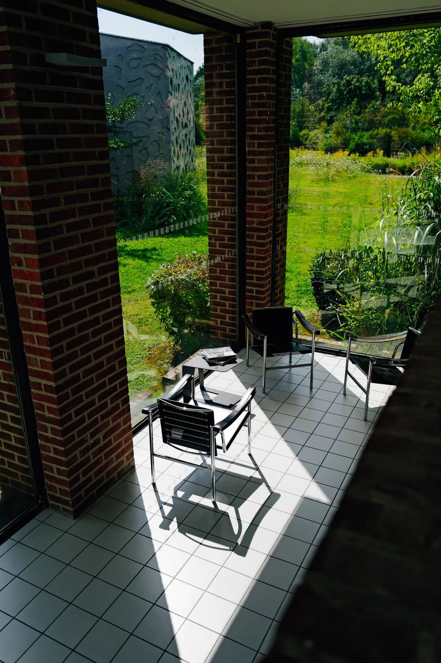 Espace vitré avec fauteuils ouvrant sur un jardin, photo d’illustration pour observer lumière et intimité