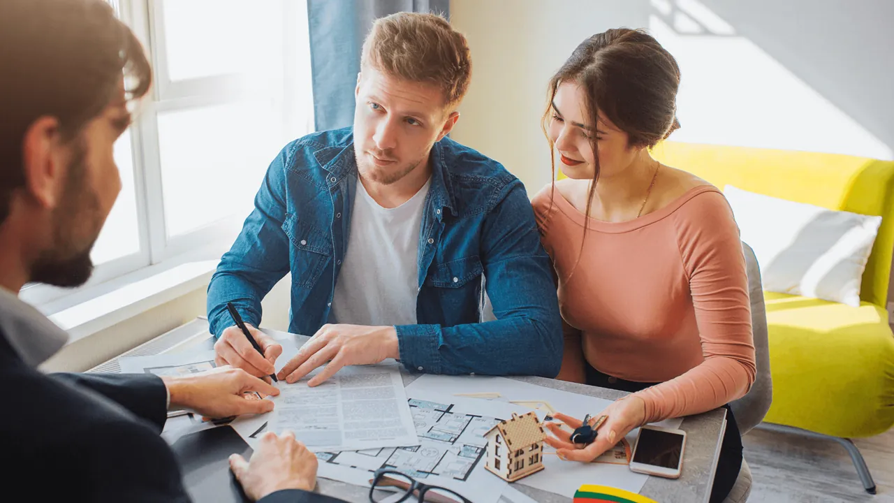 couple avec un agent immobilier qui signe un papier